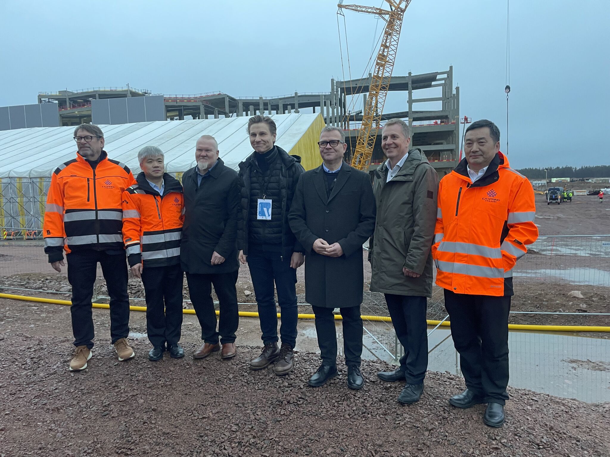 Ministerivierailun osallistujia rivissä Easpring Finlandin työmaan ministerivierailulla.